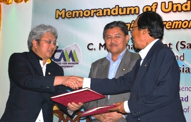 Datu Dr Hatta exchanging copies of MOU with Datu Abdul Ghafur