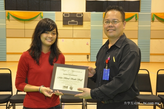 Rachel Chuo presenting a plaque to Benedict Jong of the Miri Blood Bank