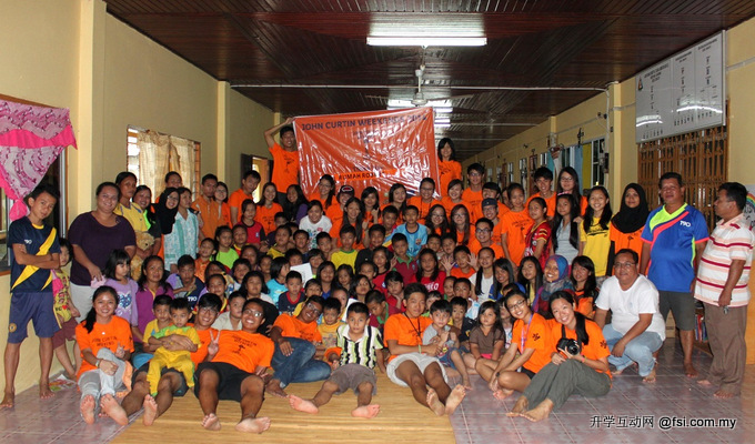 Student and staff volunteers posing for a group photo with residents of Rumah Robert.