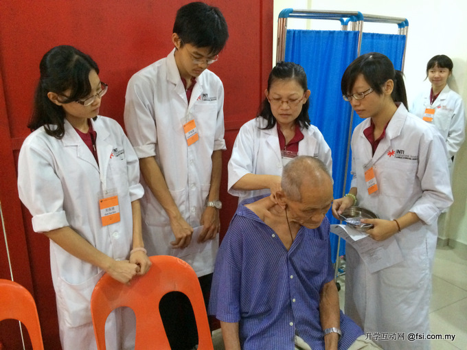 在英迪国际大学义诊主治医师带领下，中医系学生为居民提供义诊服务。