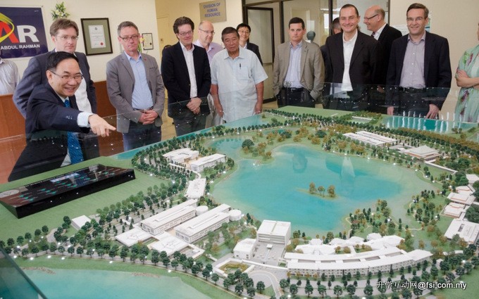 蔡贤德（左一）向来宾们展示拉曼大学霹雳校区的模型。