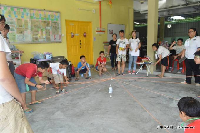 拉大生与孩童们一起玩“合作游戏”。除了合作精神，该活动也着重他们的沟通能力。