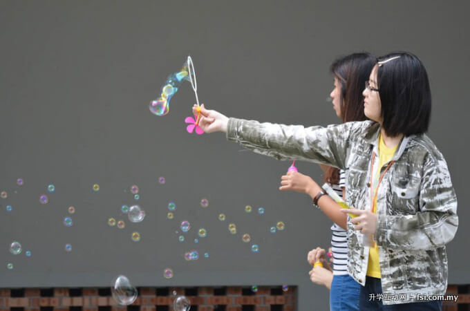 参与活动的学生舞动泡沫，回忆着童年的简单快乐。