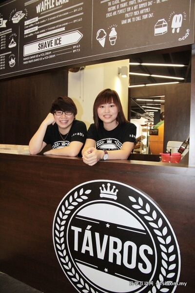 徐颖霖（左起）和邓依琳摄于他们经营的松饼和刨冰贩卖亭。这门以金牛座为商标的小生意，就设立在伯乐大学学院格林玛林大学城校区的自助餐厅内。
