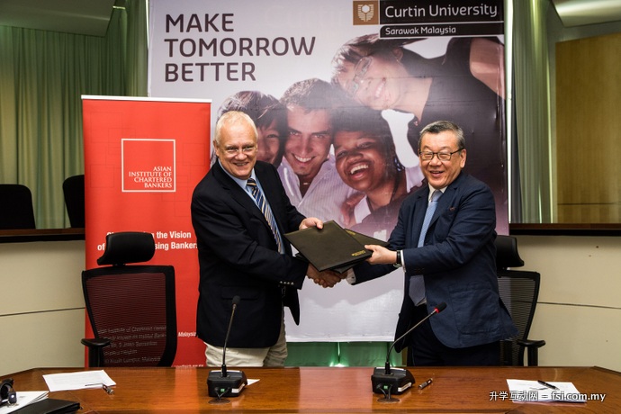 Professor Mienczakowski (left) and Mr Tay exchanging MoU documents.