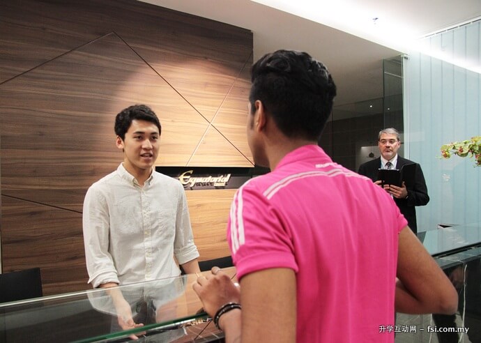 帝塚山学院大学的一名学生（左）正在伯乐大学学院的模拟酒店柜枱，练习以英语接待由伯乐学生扮演的酒店客人。