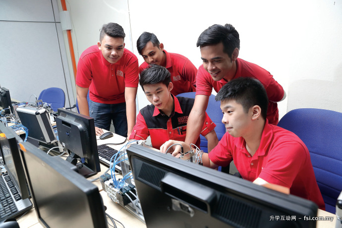 学生在OMRON可编程逻辑控制器实验室学习使用机器。