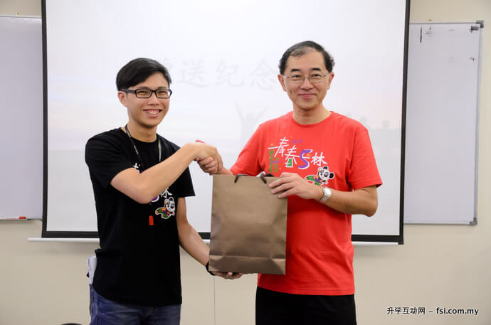 Yong (left) delivering a token of appreciation to Dato’ Mah.