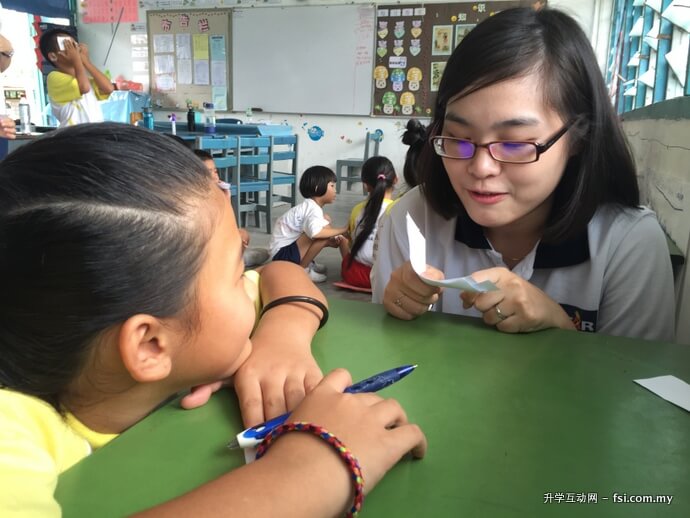 UTAR student Ming Yi conducting an activity with a student.