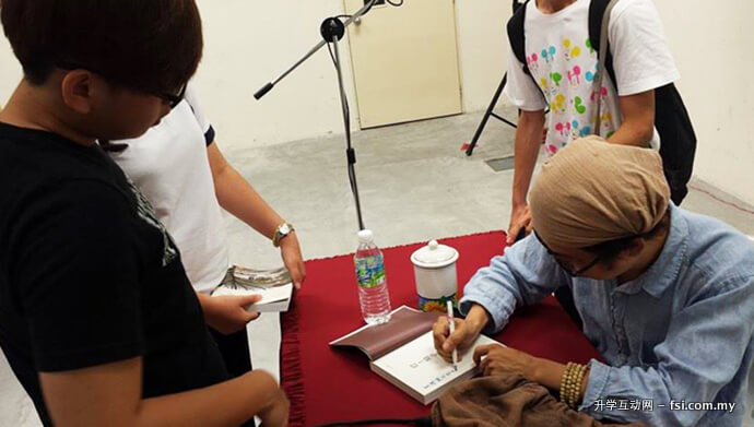Teng signing an autograph.