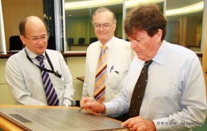 Prof Ian Kerr signing plaque while James Ng and Prof Alistair Inglis look on