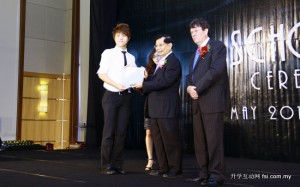 Dr Chan presenting a student his scholarship while Pro Vice-Chancellor Prof Ian Kerr looks on