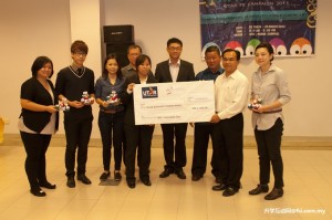 Yee (second from right) receiving the mock cheque from Lim, while others look on.