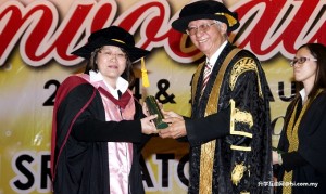 Master’s graduate Datin Paduka Chew Mei Fun (left) receiving her scroll from Tan Sri Dato’ Dr Sak