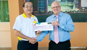 Richard Wong of Palliative Care Association Miri receiving cheque from Professor Mienczakowski.