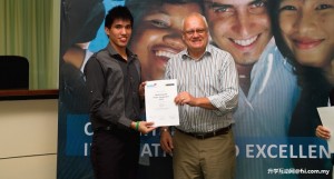 Alexander Chin receiving a certificate from Professor Mienczakowski.