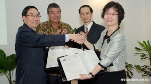Prof Chuah and Dr Liao shaking hands after signing the MoU while Tun Dr Ling and Lo look on
