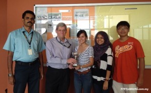 Professor Michael Cloke, Dean of Curtin Sarawak’s School of Engineering and Science, receiving the trophy from Masshiela while other team members and Dr. Ramasamy Nagarajan look on.