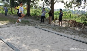 A student from SJK Sin Min (C) Tronoh Mines trying a long jump at newly rebuilt long jump track by PRECSE members