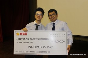 荣获工程系最佳作品的Lau Kah Kin开心从KBU院长徐从贵博士手中接过模拟支票。他的作品为Sign Language Learning Kit。