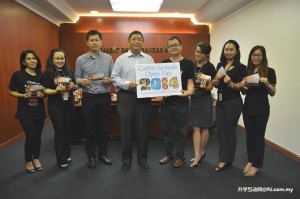Lai (centre), Hii and Leong (3rd and 5th left) and committee members displaying the logo and door gift and lucky draw tickets for this year’s Curtin Sarawak Open Day.